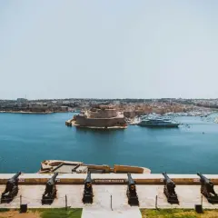 Malta wyspa, do której należy ta malownicza panorama z armatami, fortecą i luksusowymi jachtami, to perła Morza Śródziemnego.