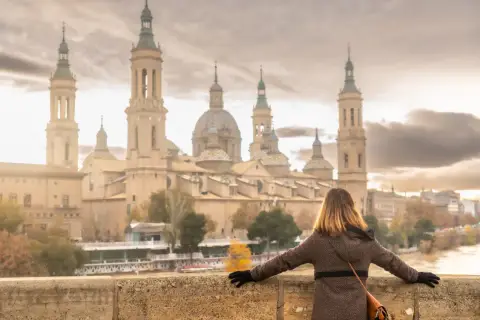 Kobieta podziwia Bazylikę del Pilar nad rzeką Ebro w Saragossie.