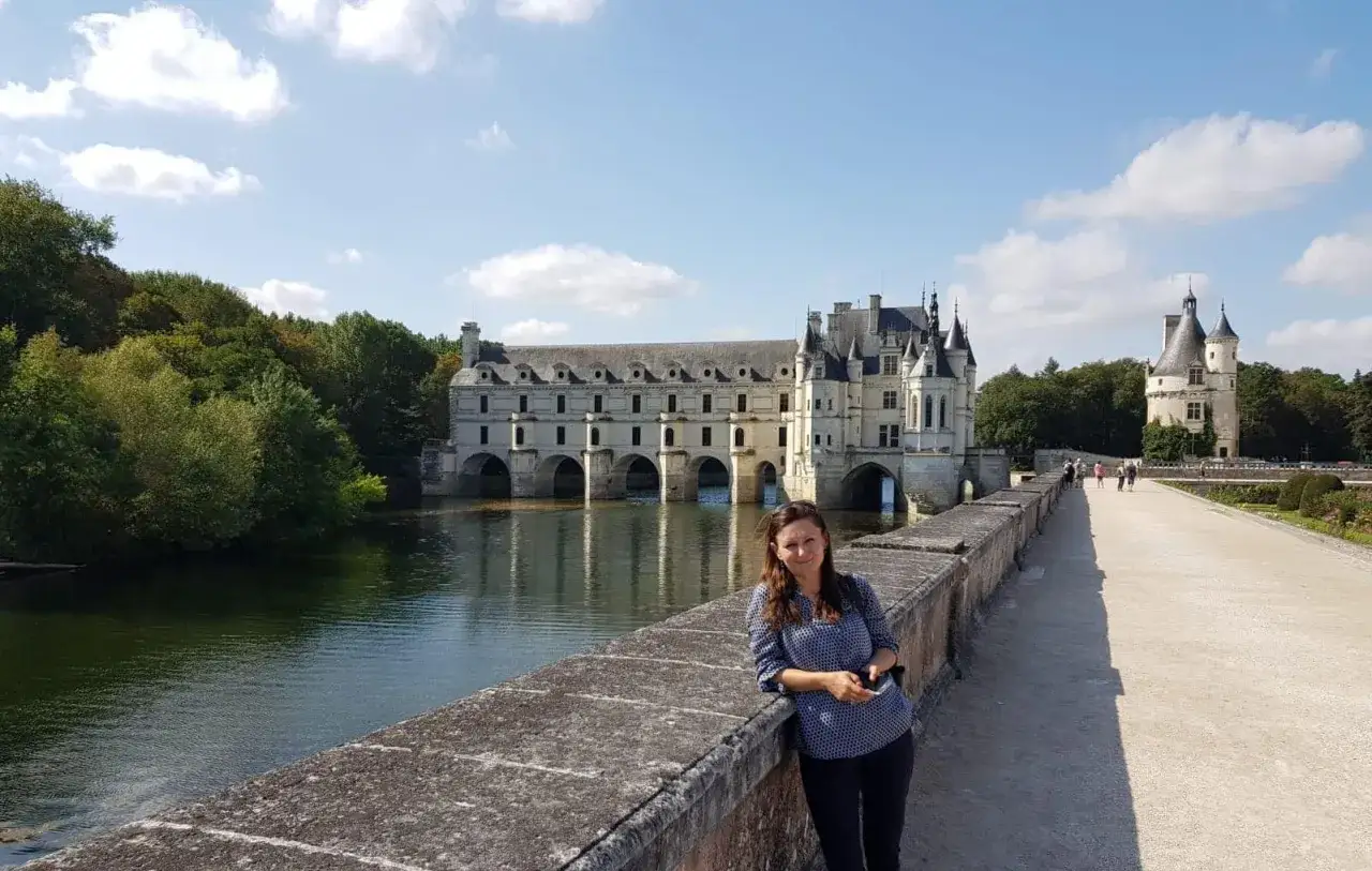 Kobieta na moście przed zamkiem Chenonceau, nad rzeką Cher, dopływem najdłuższej rzeki Francji, Loary.