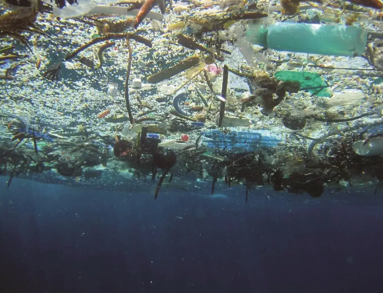 Pływająca wyspa śmieci na oceanie, pełna plastiku i odpadów, tworzy przygnębiający widok.